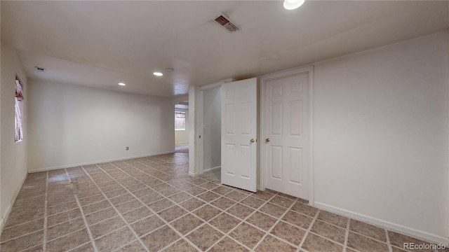 empty room with recessed lighting, visible vents, and baseboards