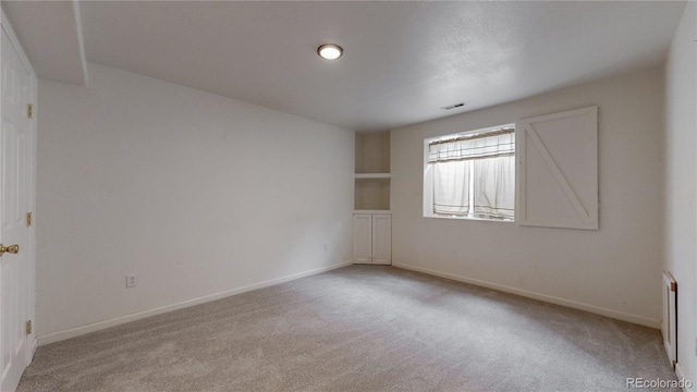 unfurnished room with baseboards, visible vents, and carpet flooring