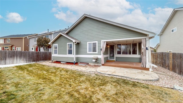 rear view of property featuring entry steps, a yard, a patio area, and a fenced backyard