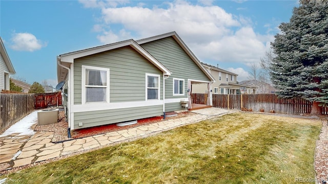 rear view of property with a patio area, a fenced backyard, and a lawn