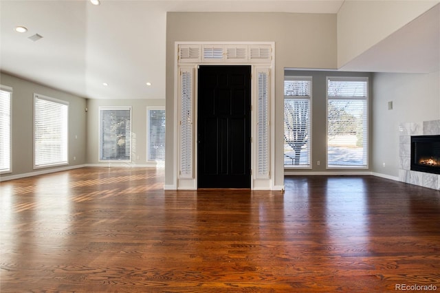 entrance foyer with a wealth of natural light, dark wood-type flooring, and a tile fireplace