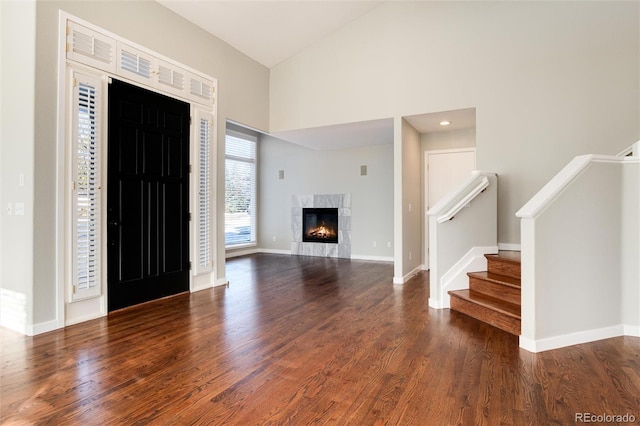 foyer with a tile fireplace, a high ceiling, and hardwood / wood-style flooring