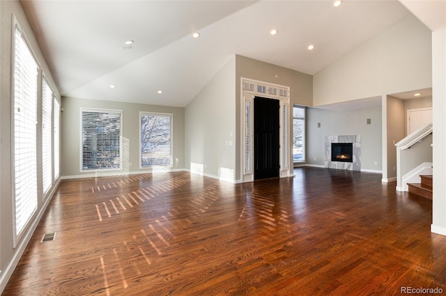 unfurnished living room with a fireplace, high vaulted ceiling, and dark wood-type flooring