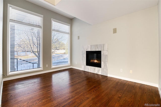 unfurnished living room with a tile fireplace and hardwood / wood-style floors