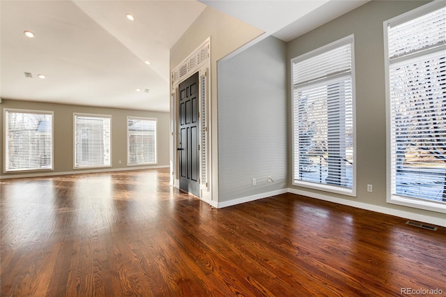 unfurnished living room featuring wood-type flooring, lofted ceiling, and a wealth of natural light