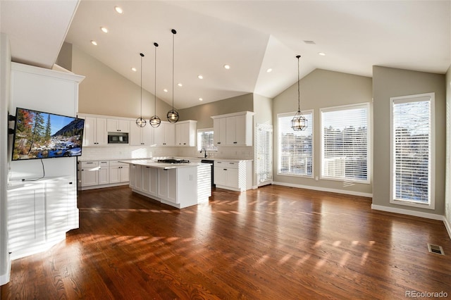 kitchen featuring decorative backsplash, dark hardwood / wood-style flooring, a kitchen island, pendant lighting, and white cabinetry