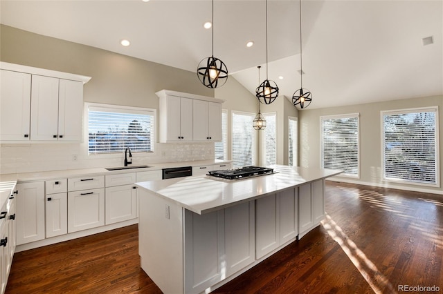 kitchen featuring white cabinets, a center island, and sink