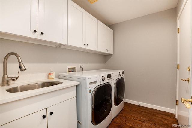 washroom with dark hardwood / wood-style flooring, cabinets, separate washer and dryer, and sink