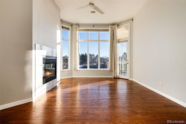 unfurnished living room with ceiling fan, a fireplace, and dark hardwood / wood-style floors