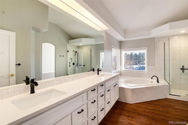 bathroom featuring hardwood / wood-style floors, vanity, vaulted ceiling, and shower with separate bathtub