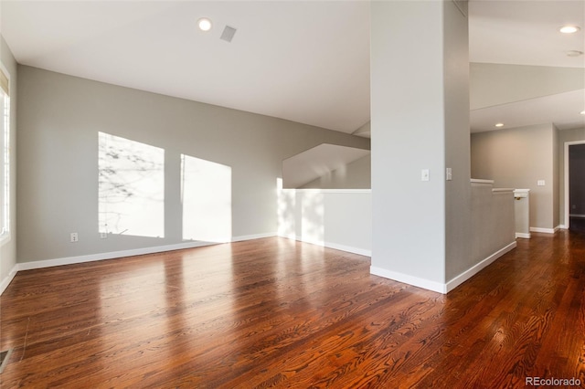 unfurnished room featuring dark hardwood / wood-style flooring and vaulted ceiling