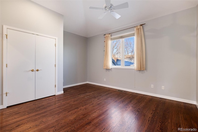 unfurnished bedroom featuring dark hardwood / wood-style flooring, a closet, ceiling fan, and lofted ceiling