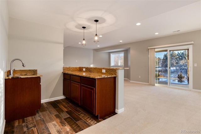 kitchen with kitchen peninsula, plenty of natural light, and decorative light fixtures