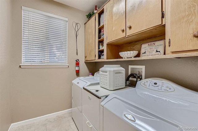 laundry area with washer and clothes dryer, cabinets, and light tile patterned floors