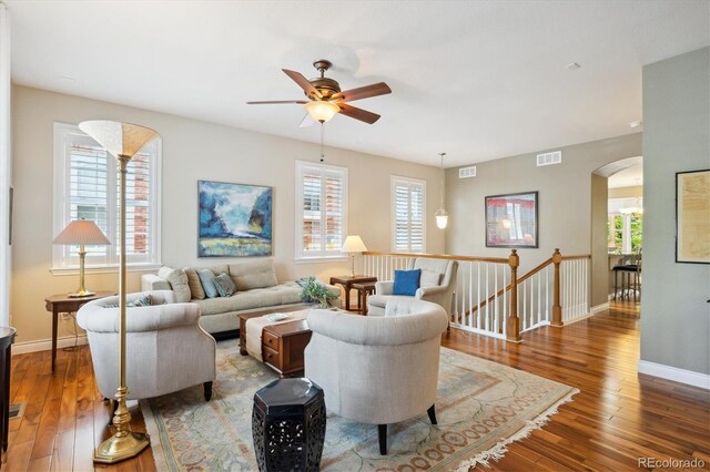 2723 Galena St, Denver, CO 80238 - living room featuring arched walkways, a ceiling fan, wood-type flooring, and baseboards