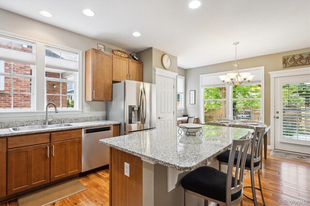 2723 Galena St, Denver, CO 80238 - kitchen with appliances with stainless steel finishes, a sink, light wood-type flooring, a chandelier, and recessed lighting