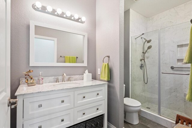 2723 Galena St, Denver, CO 80238 - bathroom featuring toilet, a shower stall, vanity, and a textured wall