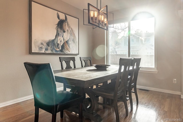 dining area with a chandelier and dark hardwood / wood-style flooring