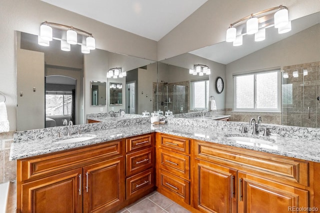 bathroom featuring tile patterned floors, vaulted ceiling, vanity, and a shower with door