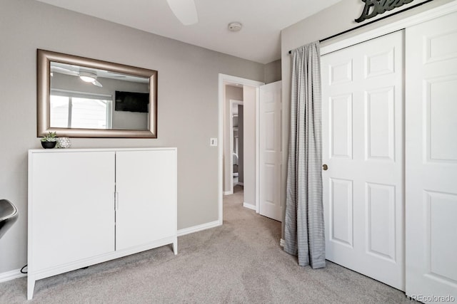 unfurnished bedroom with light carpet, a closet, and ceiling fan