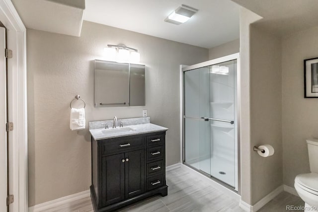 bathroom with toilet, vanity, and an enclosed shower