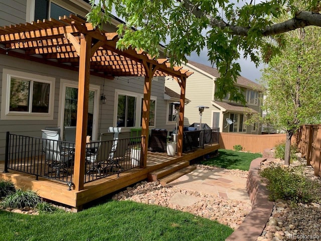 back of property featuring a wooden deck and a pergola