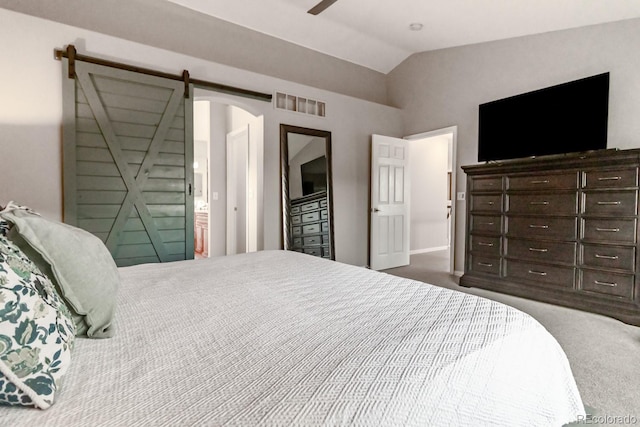 bedroom featuring lofted ceiling, carpet flooring, and a barn door