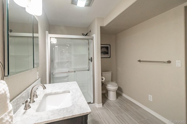 bathroom featuring vanity, an enclosed shower, and toilet