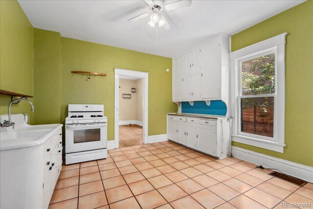 4461 Vrain St, Denver, CO 80212 - kitchen featuring white gas range, white cabinetry, a ceiling fan, light countertops, and light tile patterned floors
