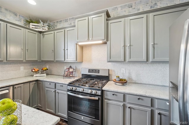 kitchen featuring stainless steel appliances, light stone countertops, and backsplash