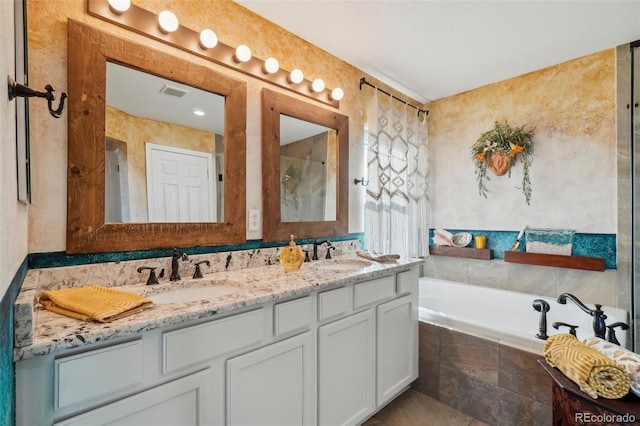 bathroom featuring vanity and a relaxing tiled tub