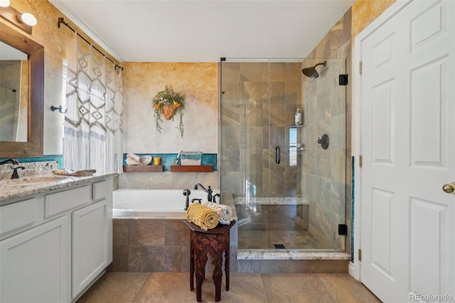 bathroom with vanity and shower with separate bathtub