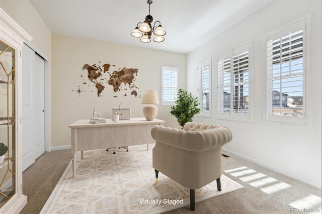 carpeted home office with an inviting chandelier