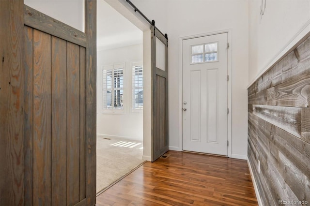 entryway with a barn door and hardwood / wood-style flooring