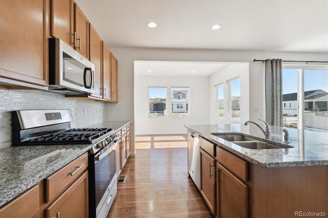 kitchen with a center island with sink, a wealth of natural light, sink, and appliances with stainless steel finishes