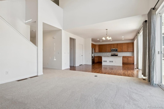 unfurnished living room with dark hardwood / wood-style floors and an inviting chandelier