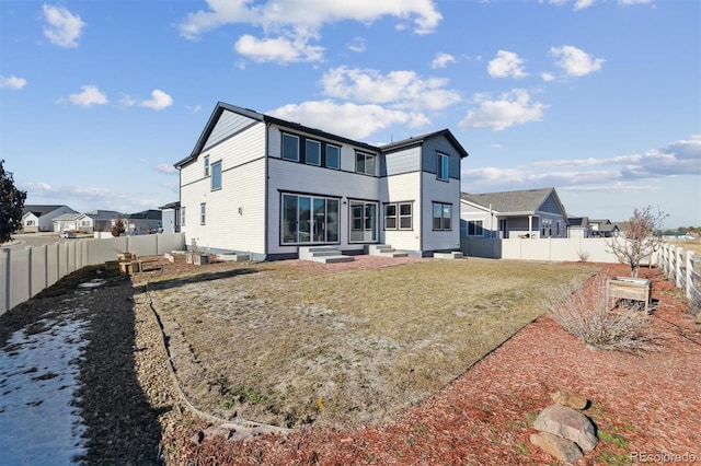 rear view of house featuring a yard