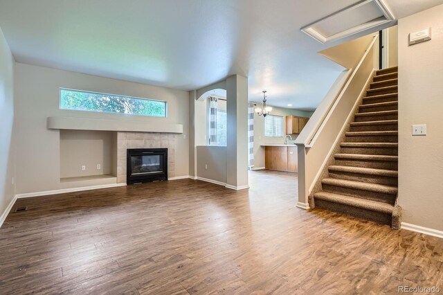 21767 Silver Meadow Ln, Parker, CO 80138 - unfurnished living room with a tiled fireplace, wood finished floors, and stairs