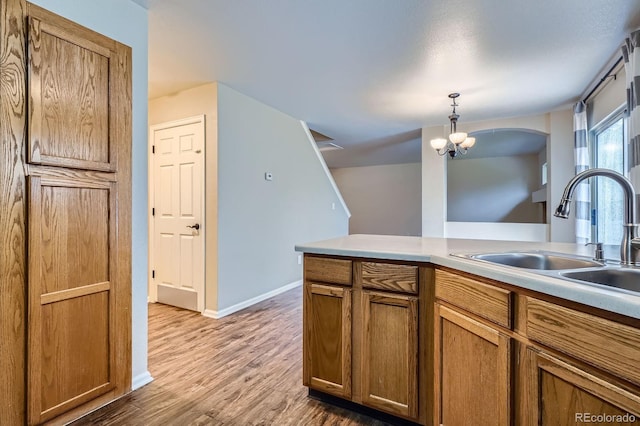 21767 Silver Meadow Ln, Parker, CO 80138 - kitchen featuring wood finished floors, brown cabinets, hanging light fixtures, and light countertops