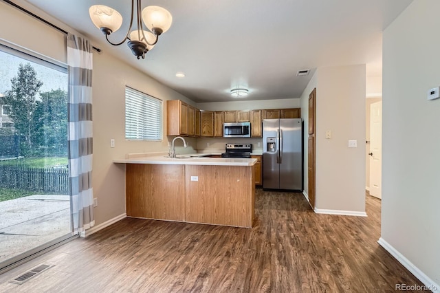 21767 Silver Meadow Ln, Parker, CO 80138 - kitchen featuring stainless steel appliances, a peninsula, dark wood finished floors, light countertops, and a chandelier