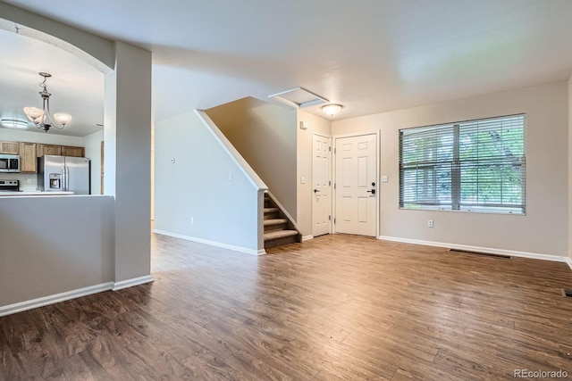 21767 Silver Meadow Ln, Parker, CO 80138 - unfurnished living room featuring wood finished floors, arched walkways, and stairs