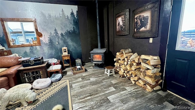 misc room with hardwood / wood-style flooring, a wood stove, and a wealth of natural light