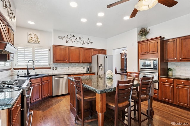 7804 Silverweed Way, Lone Tree, CO 80124 - kitchen with stainless steel appliances, a sink, decorative backsplash, a ceiling fan, and a kitchen breakfast bar