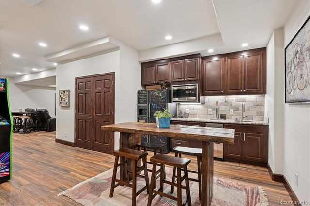7804 Silverweed Way, Lone Tree, CO 80124 - kitchen featuring stainless steel microwave, dark brown cabinets, a sink, black fridge, and backsplash
