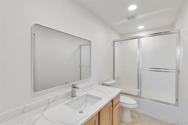 full bathroom featuring vanity, toilet, and bath / shower combo with glass door