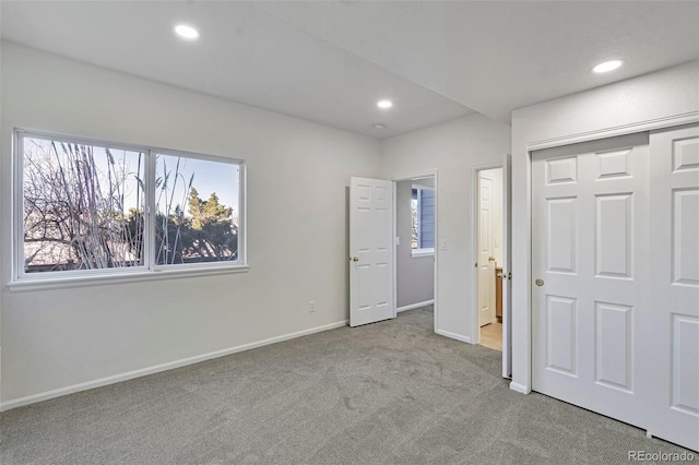 unfurnished bedroom featuring light carpet and a closet