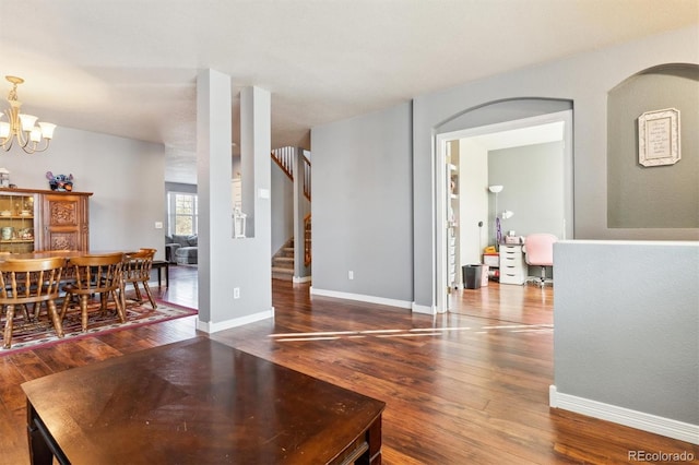 living room with dark wood-type flooring and a chandelier