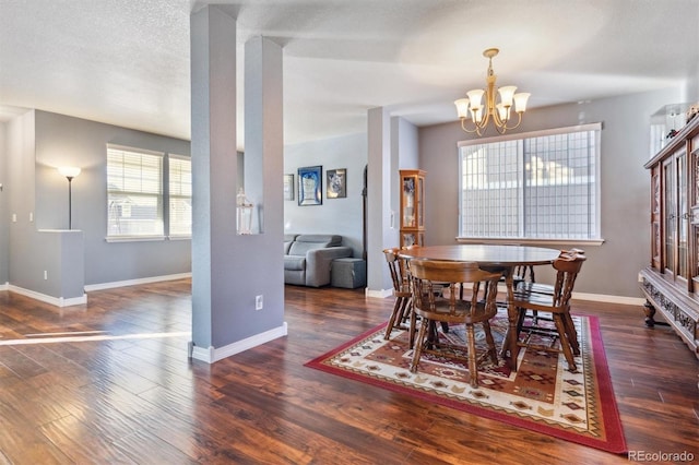 dining room with dark hardwood / wood-style flooring, a textured ceiling, and an inviting chandelier