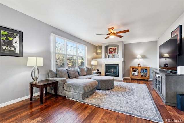 living room with ceiling fan, a fireplace, and dark hardwood / wood-style flooring