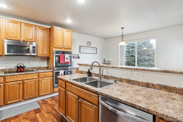 kitchen with pendant lighting, sink, dark wood-type flooring, and stainless steel appliances